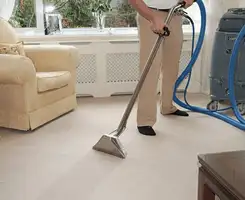 Carpet cleaning professional removing dirt and stains with a hot-water extraction tool in a home, Miami, FL.