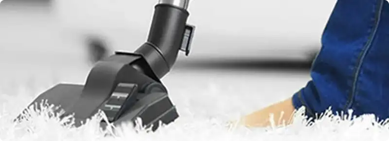 Close-up of a professional vacuuming a white carpet in Hollywood.